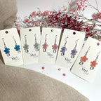 Lemmikki-korvakorut väriä heijastavalla helmellä